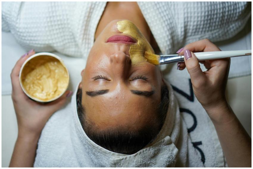A woman enjoying a gold facial mask for relaxation