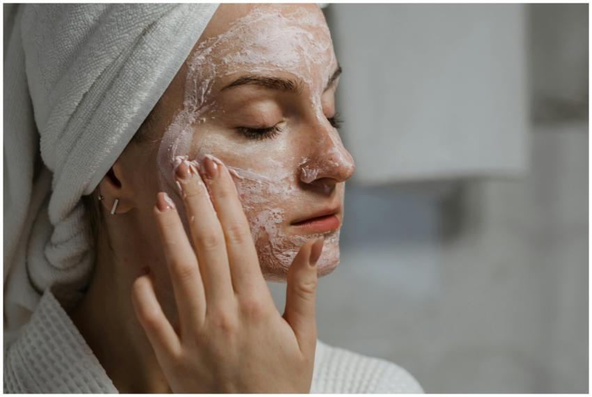A woman applying a clay mask as part of her self-c