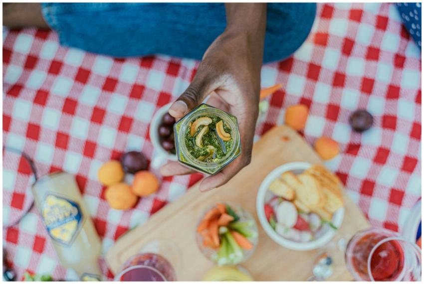 Close-up of a hand holding a jar of cashew pesto o
