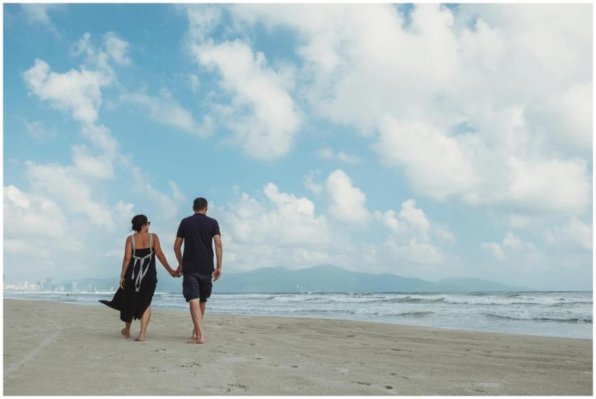 A couple holding hands walking along a serene beac