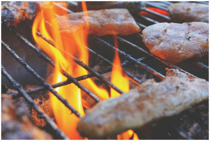 Close-up of grilling meat on open flames showcasin