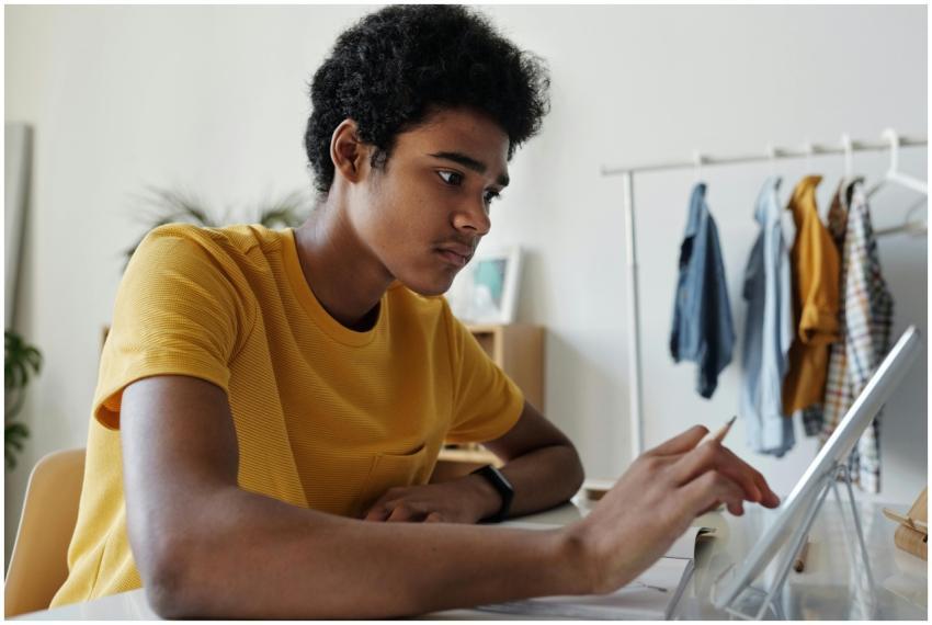 Teenage boy engaged in online learning using a tab