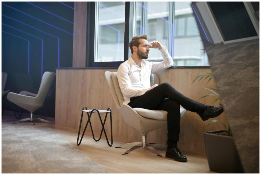 A thoughtful man in a modern office interior, sitt