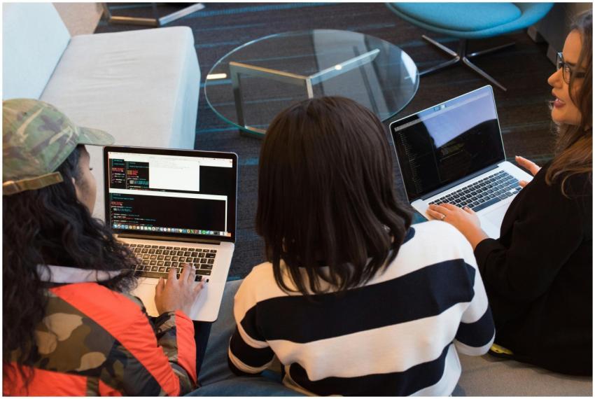 Three women working on laptops in a stylish office
