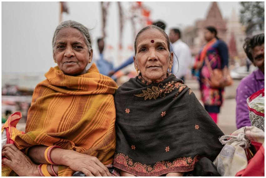 Two elderly women in traditional Indian attire sit