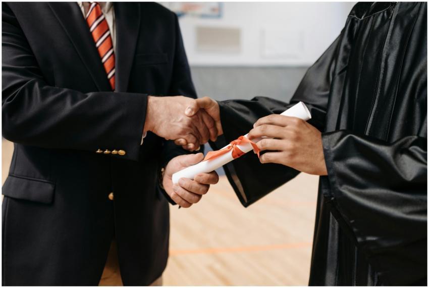 Close-up of a graduate receiving diploma during a