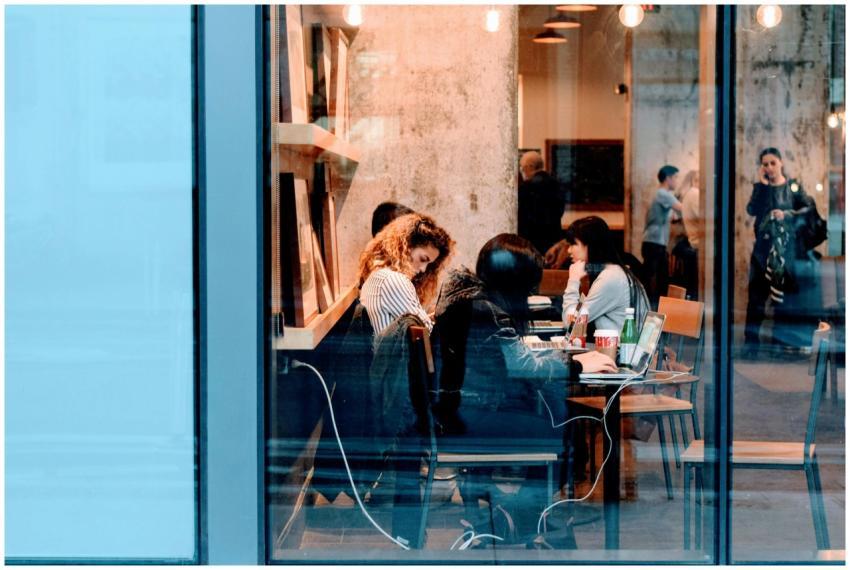 Group of adults working inside a stylish city cafe
