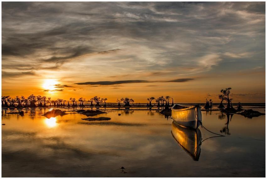 A tranquil scene of a boat at sunset with beautifu