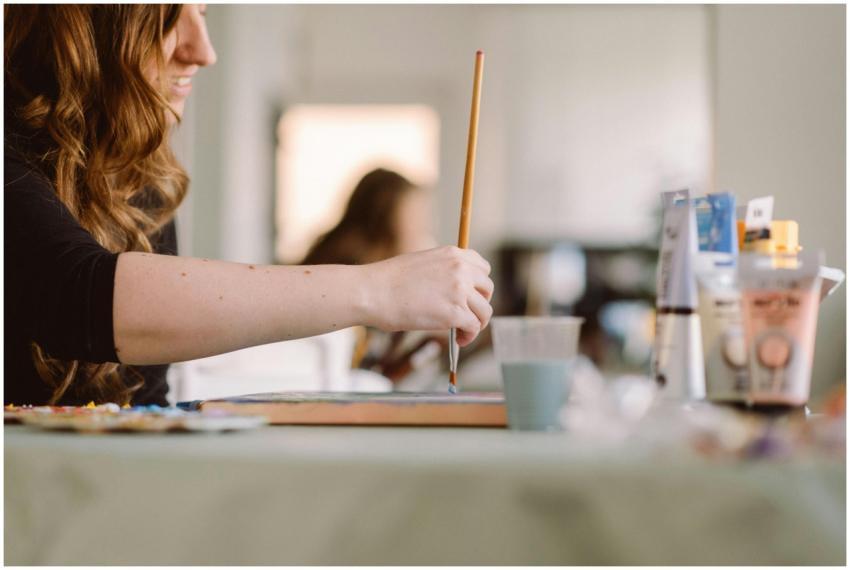 A woman artist painting in a sunlit studio, captur