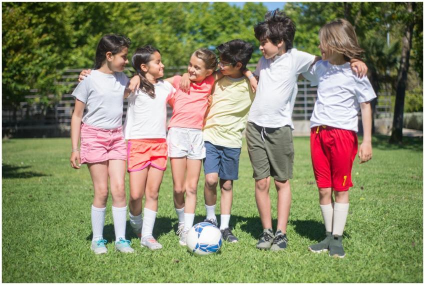 Children playing soccer on a sunny day in a park,