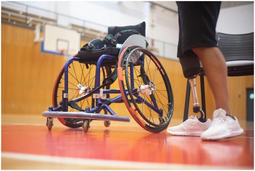 Close-up of a wheelchair and prosthetic leg on a b