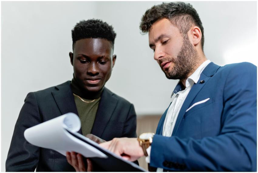 Two businessmen in suits discuss important documen