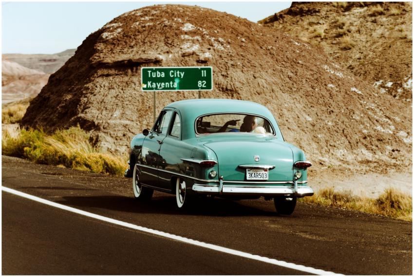 Classic vintage car driving through the scenic des