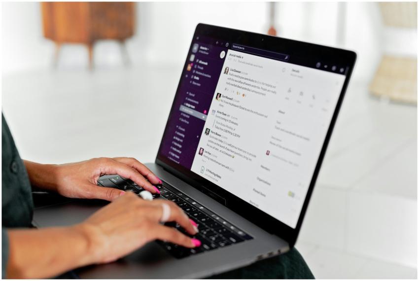 A woman types on a laptop using a messaging app in