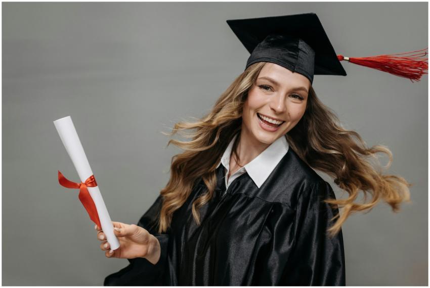 Happy woman in graduation gown with diploma, celeb