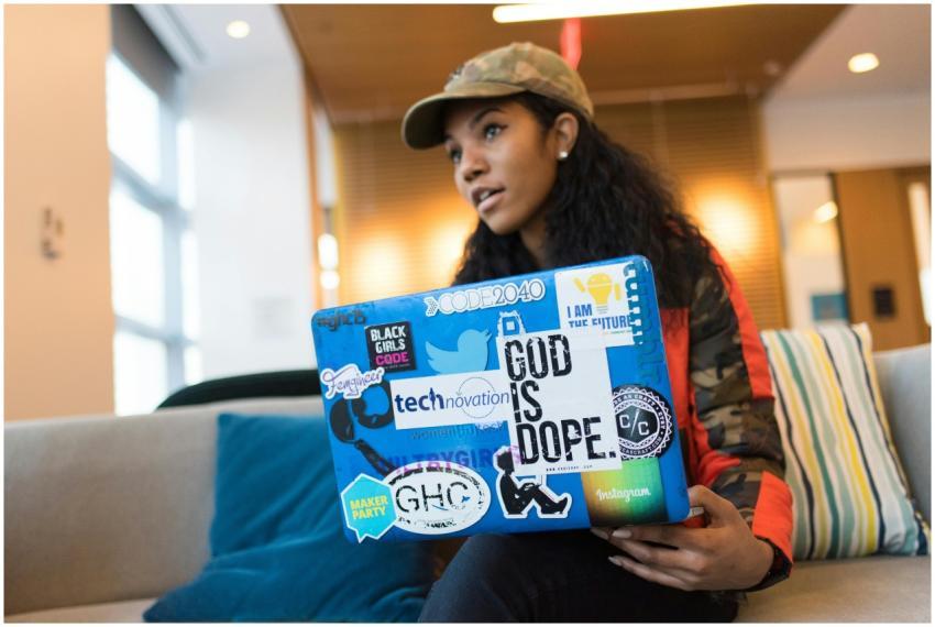 Tech-savvy woman with sticker-decorated laptop wor