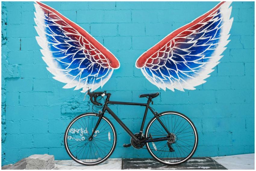 A stylish bicycle parked against a vibrant blue wa