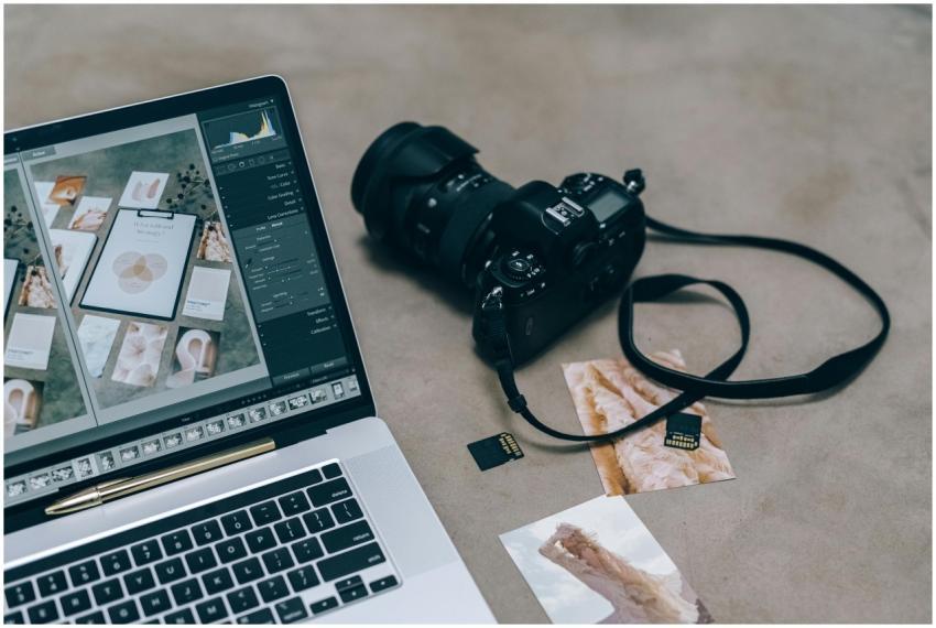 Laptop with editing software alongside DSLR camera