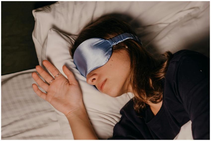 A woman rests peacefully indoors wearing a blue si