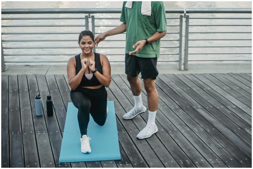 A woman doing lunges on a yoga mat outdoors with g