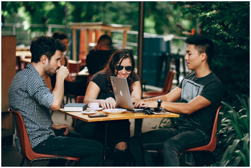 A group of young adults working on a laptop at an