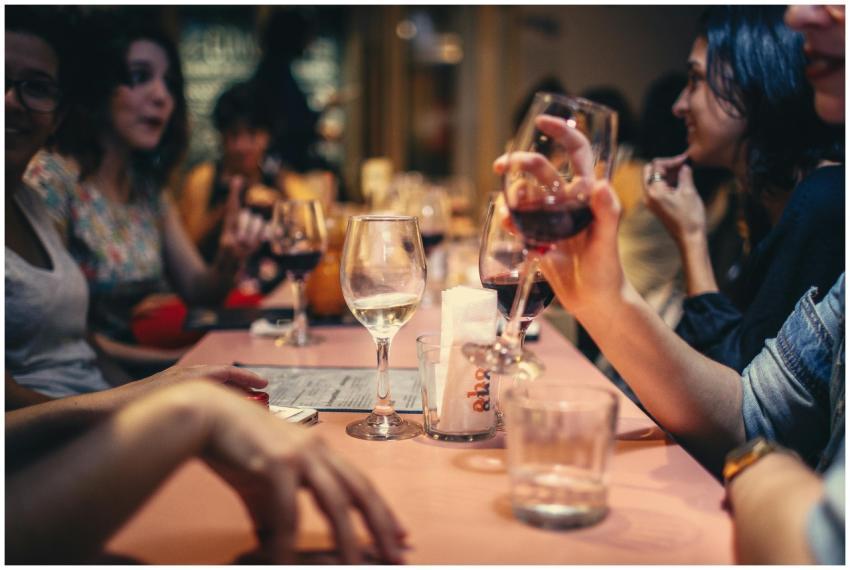A lively scene of friends enjoying wine and conver