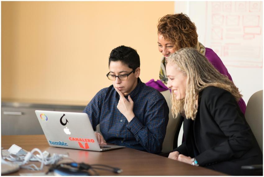 Three colleagues working together on a laptop, fos