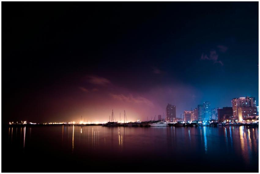 Stunning night view of a cityscape with boats refl
