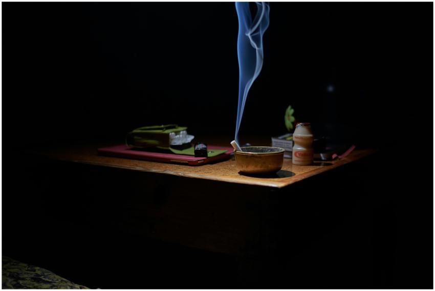 A dramatic image of a lit cigarette in an ashtray