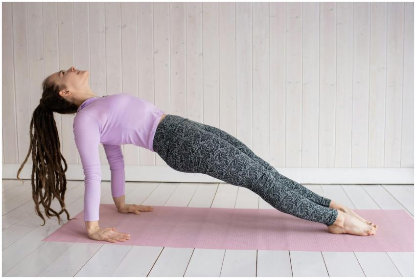 Woman with dreadlocks practicing yoga indoors on a