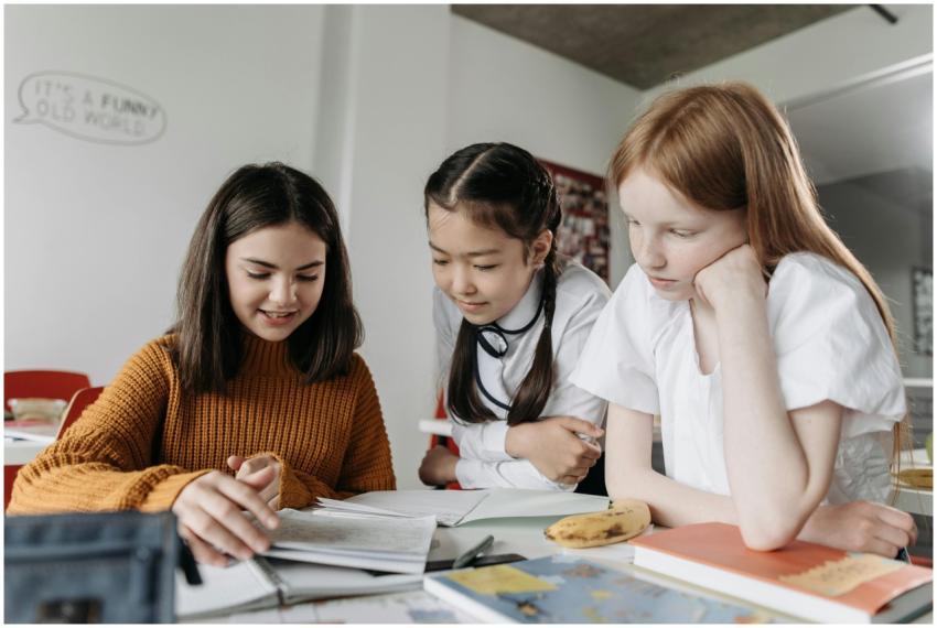 Three diverse schoolgirls working together over bo