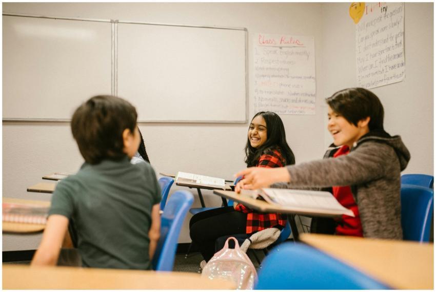 Happy students interacting and laughing together i