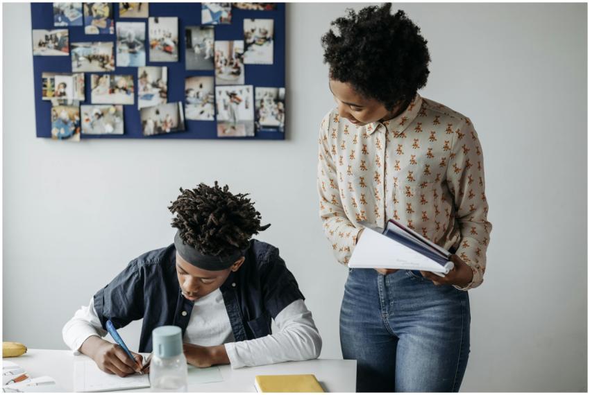 A teacher assists a student in a lively classroom
