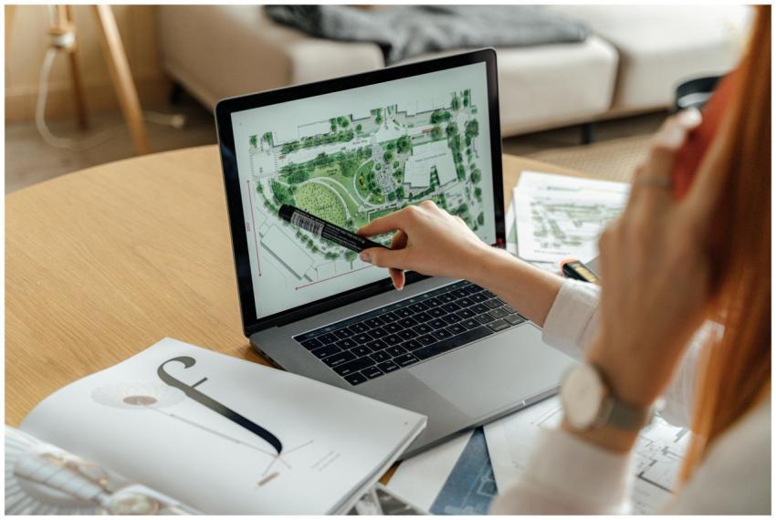 Architect reviewing landscape design on laptop, en