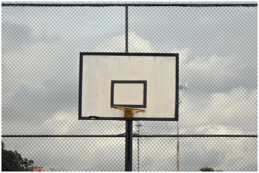 A solitary basketball hoop on an empty court with