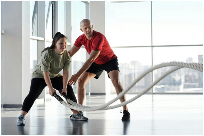 Woman and trainer engaging in rope workout in a br