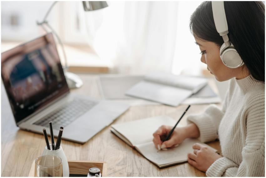 Asian woman focused on study, writing notes during