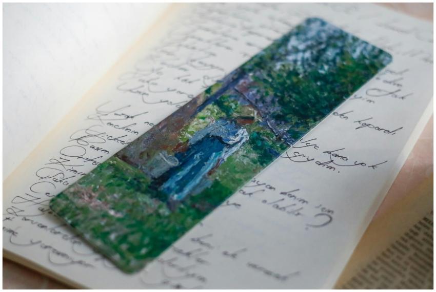 A colorful artistic bookmark rests in an open jour