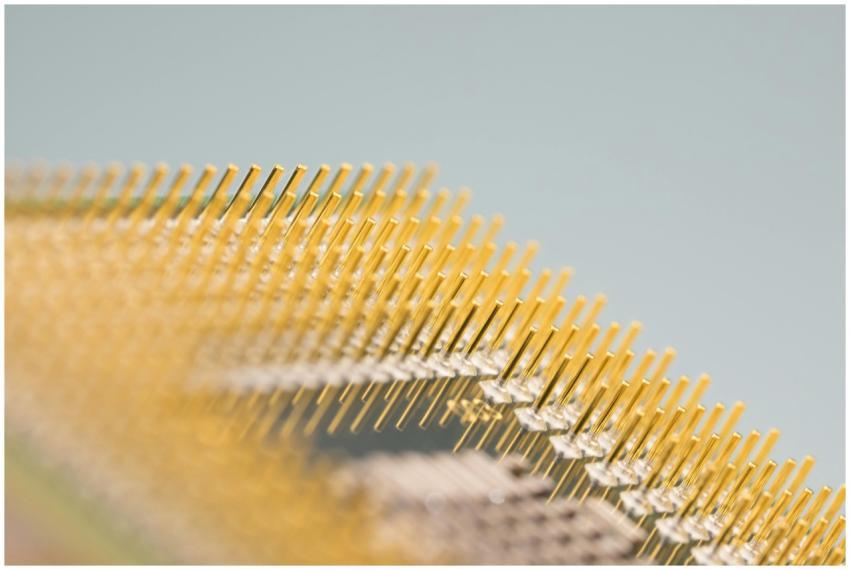 Detailed close-up of gold CPU pins, showcasing tec