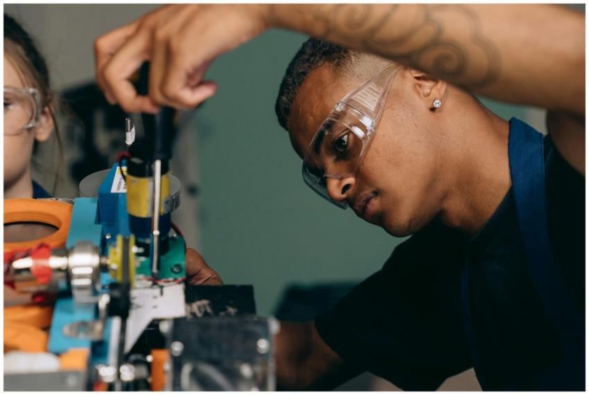 Two young technicians focus on electronic equipmen