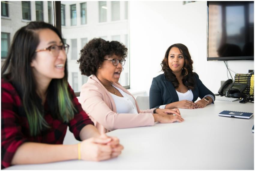Three diverse women discussing in a bright office,