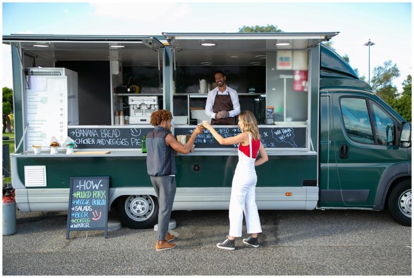 Happy couple clinking drinks enjoying street food