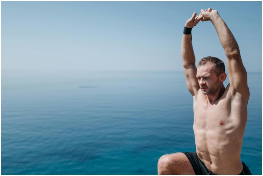 A fit man performs a stretching routine beside a v