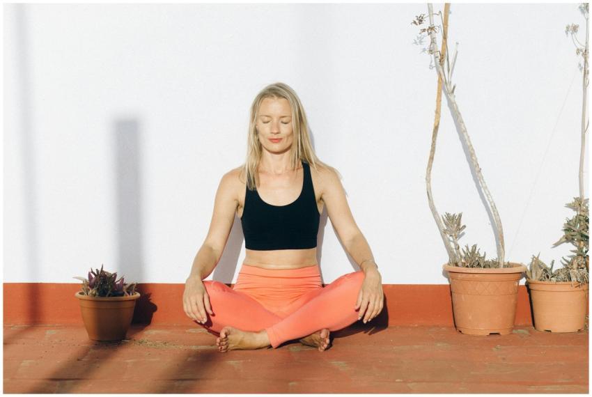 A woman meditating outdoors in activewear, enjoyin