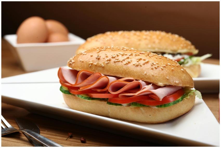 Tasty ham and vegetable sandwich on sesame bun wit