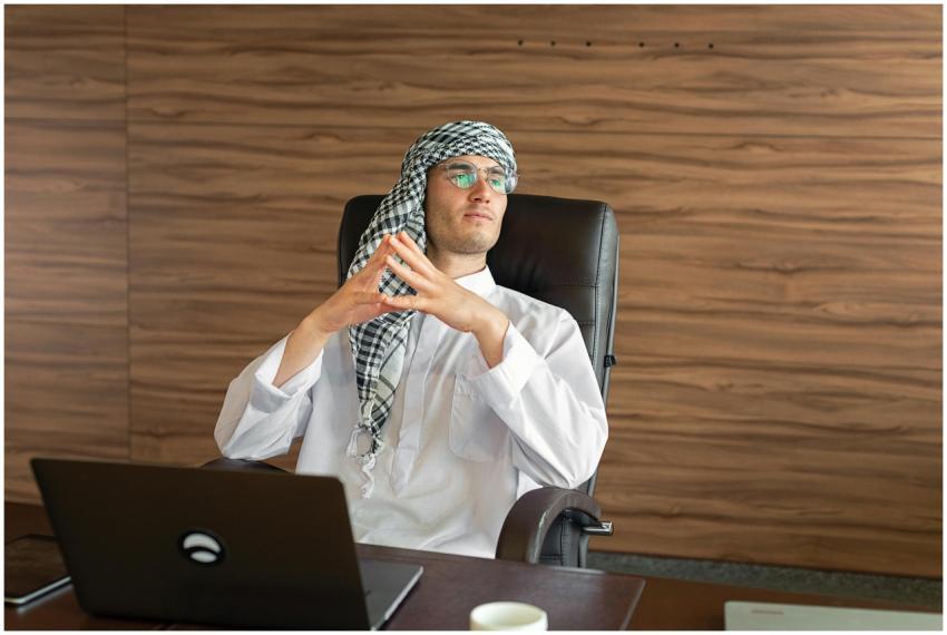 A thoughtful Middle Eastern businessman sits at a