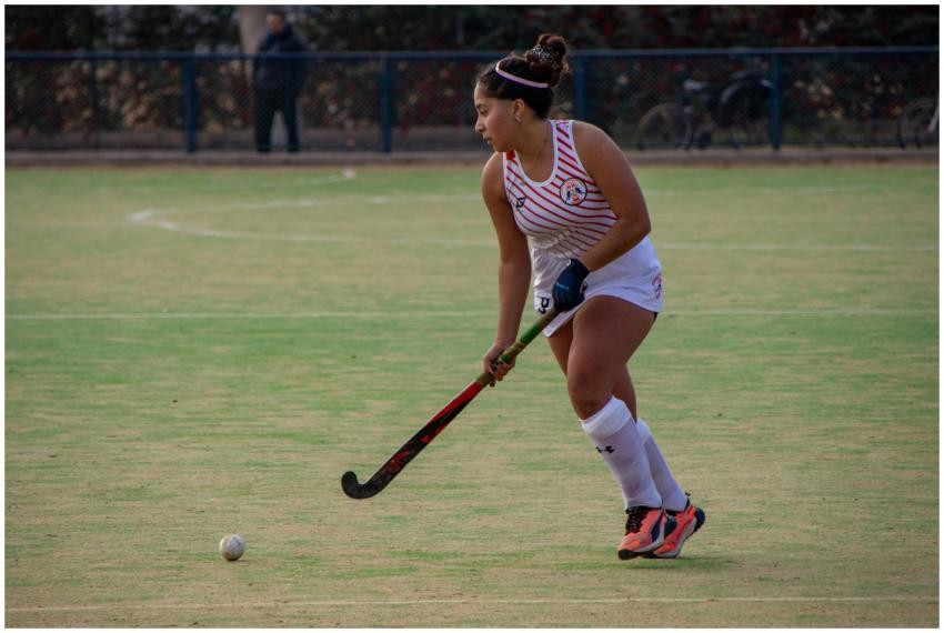 Female field hockey player in action on the field,