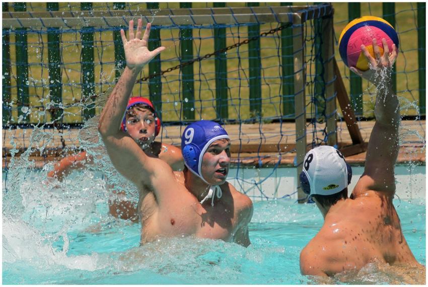 Three male athletes engaging in a dynamic water po