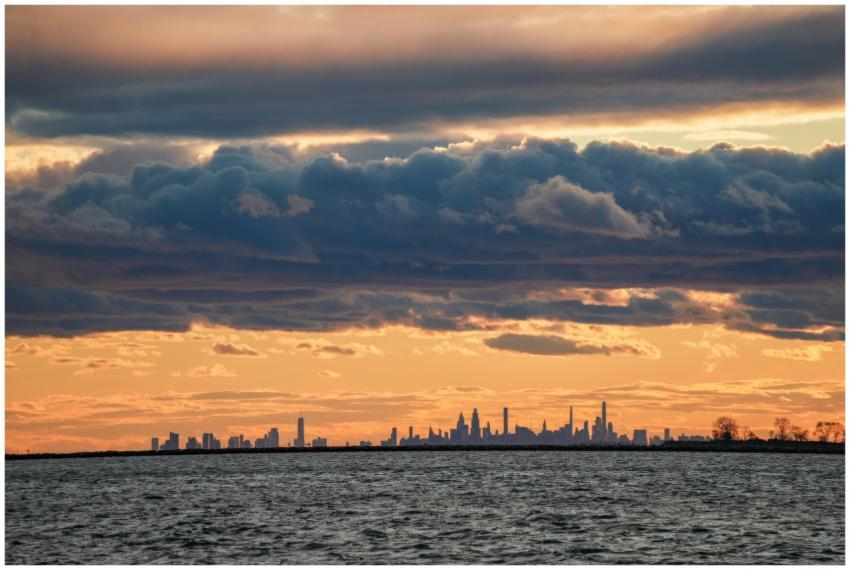Silhouette of New York City skyline against a dram