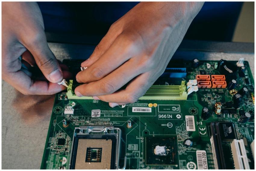 Hands carefully assembling a computer motherboard,
